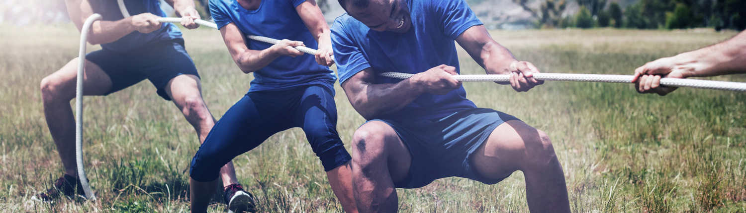 People playing tug of war during obstacle training course